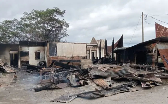 Warga dan petugas berjibaku memadamkan api kebakaran yang meludeskan tiga rumah adat Batak di Samosir.