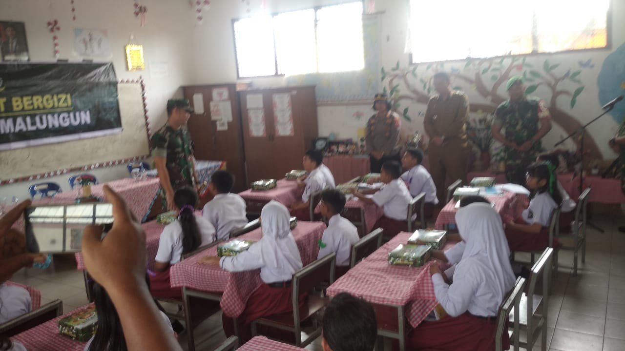 Dandim 0207/Simalungun Letkol Inf Agus Dian Pringgana saat membagikan Makanan Bergizi Gratis kepada murid SDN 124395 Jalan Nagur, Pematangsiantar.