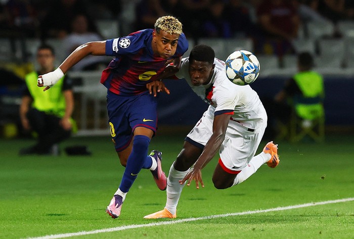 Lamine Yamal beraksi melewati hadangan pemain PSG dalam laga Liga Champions di Stadion Olimpico Lluis Companys, Kamis (2/10/2025).