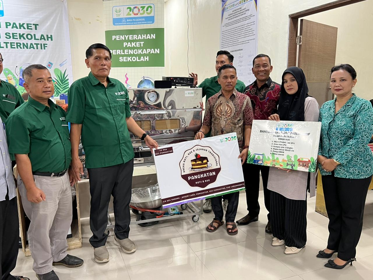 Regional Head Sumatra Utara Asian Agri, Herman Sembiring, menyerahkan bantuan pendidikan dan peralatan UMKM kepada masyarakat Desa Pangkatan, Labuhanbatu.