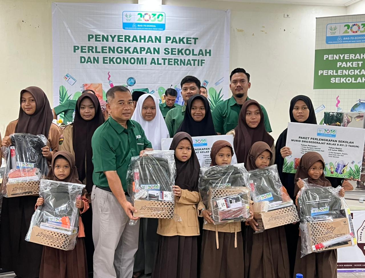 Regional Head Sumatra Utara Asian Agri, Herman Sembiring, menyerahkan bantuan pendidikan dan peralatan UMKM kepada masyarakat Desa Pangkatan, Labuhanbatu.