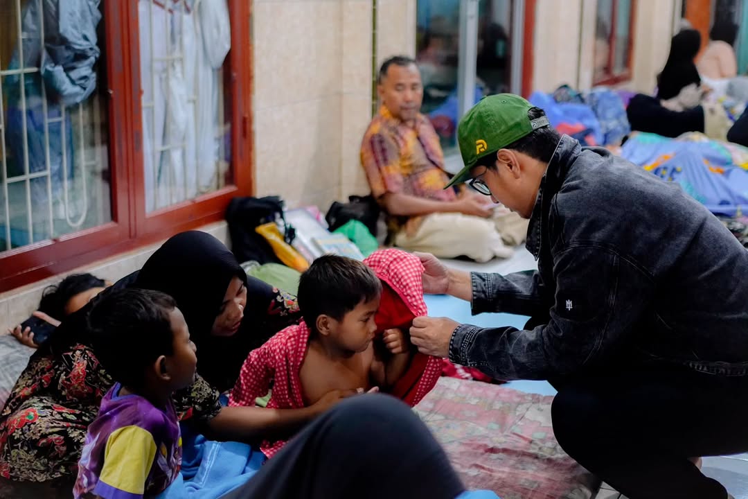 Wali Kota Medan Rico Waas berinteraksi dengan seorang anak dalam tinjauan banjir di Jalan Luku Gang Bersama, Kwala Bekala, Medan Johor pada Sabtu malam (11/10/2025).