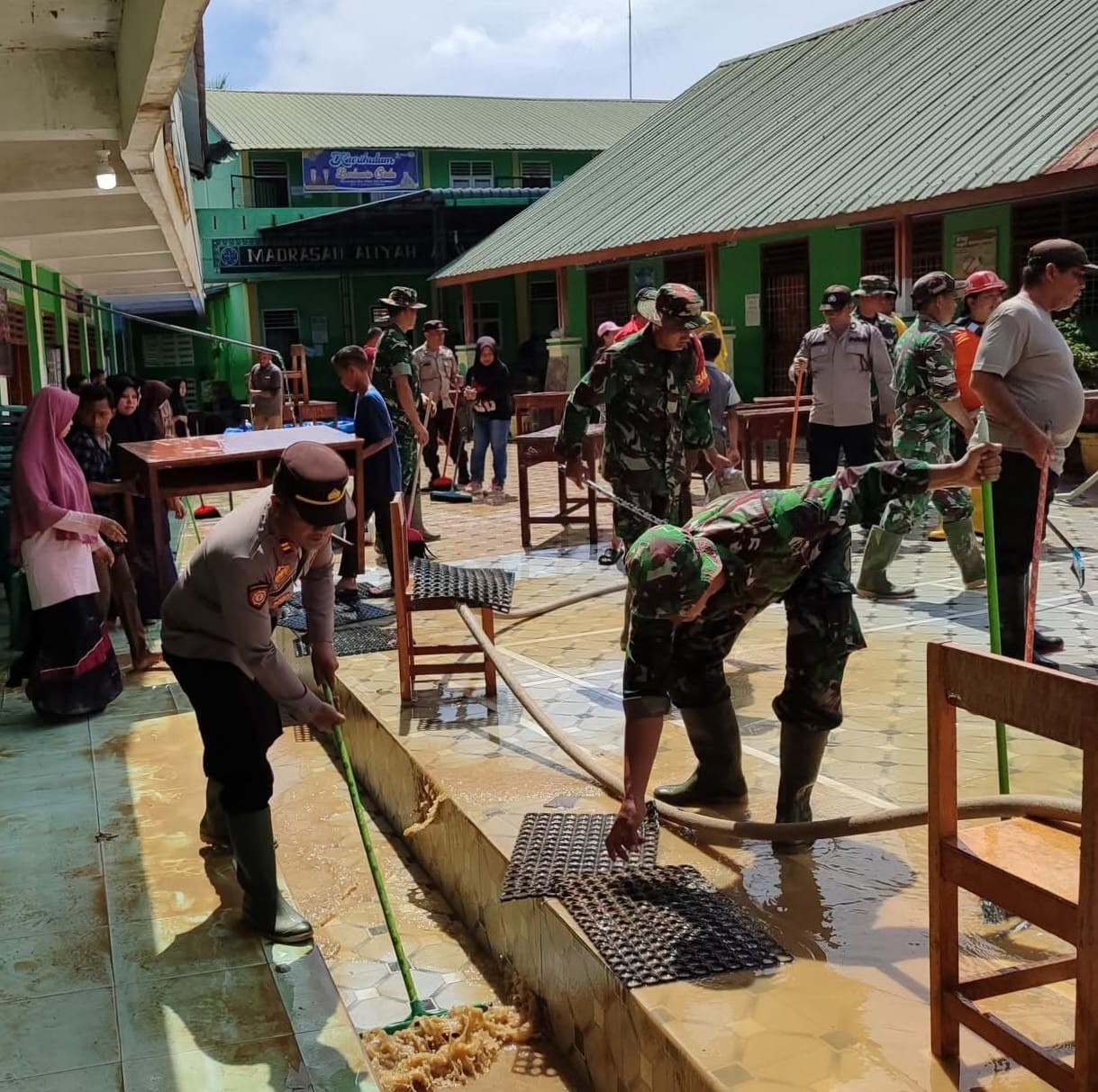 Petugas dan warga bergotong royong membersihkan lumpur sisa banjir di Serbelawan, Simalungun.