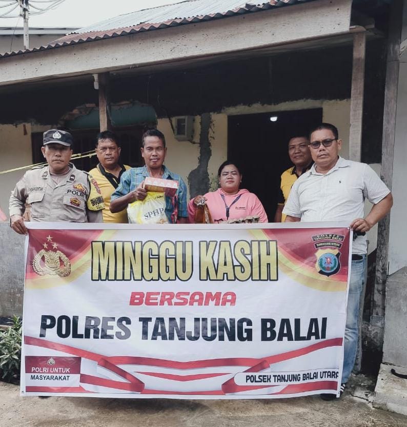 Personel Polres Tanjungbalai menyerahkan bantuan sembako kepada warga saat kegiatan &ldquo;Minggu Kasih&rdquo; di Kelurahan Kuala Silo Bestari, Minggu (12102025).