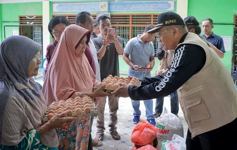 Bupati Simalungun Anton Achmad Saragih menyerahkan bantuan kepada warga terdampak banjir.