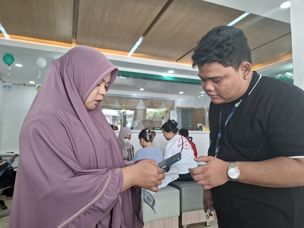 Salahsatu Magenta di Kantor Cabang Pegadaian Pematangsiantar mengajari nasabah melakukan transaksi tabungan emas di aplikasi Pegadaian Digital, Tring!.