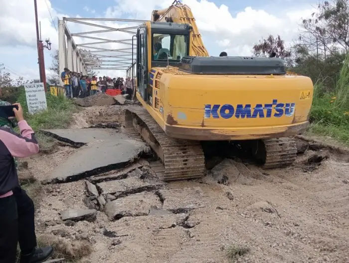 Alat berat dikerahkan memperbaiki plat injak Jembatan Binanga Aron yang amblas di Desa Pardugul, Kecamatan Pangururan, Kamis (16/10/2025).