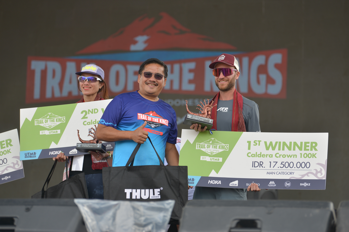 Sekdaprov Sumut Togap Simangunsong menyerahkan piala kepada para pemenang Trail of The Kings Lake Toba by UTMB di Waterfront Pangururan, Samosir, Minggu (19/10).