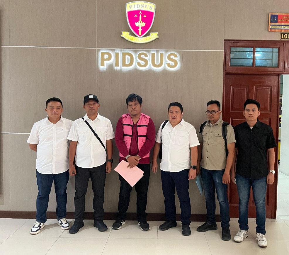 Tersangka ARP Menggunakan Rompi Jingga dengan tangan diborgol, diapit tim jaksa penyidik dari Kejari Gunungsitoli, berada di kantor Kejati Sumut.