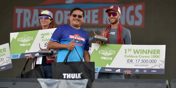 Sekdaprov Sumut Togap Simangunsong menyerahkan piala kepada para juara Trail of The Kings UTMB Series Danau Toba 2025 di Waterfront Pangururan, Minggu (19/10/2025).