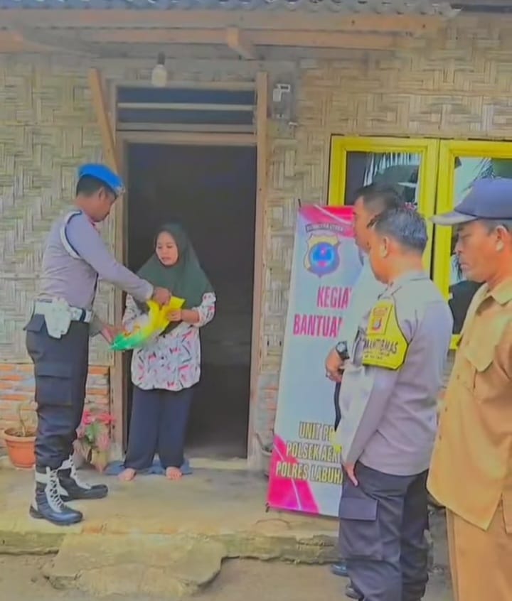 Personel Polsek Aek Natas saat menyalurkan bantuan sembako kepada masyarakat kurang mampu di Labura.