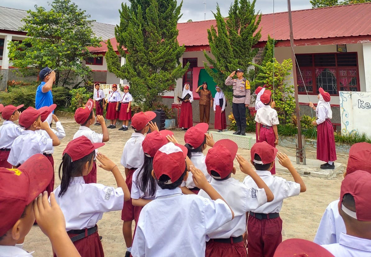 Bhabinkamtibmas Polsek Siantar Marihat bertindak sebagai pembina upacara di UPTD SDN 124386 Jalan Pisang, Pematangsiantar.