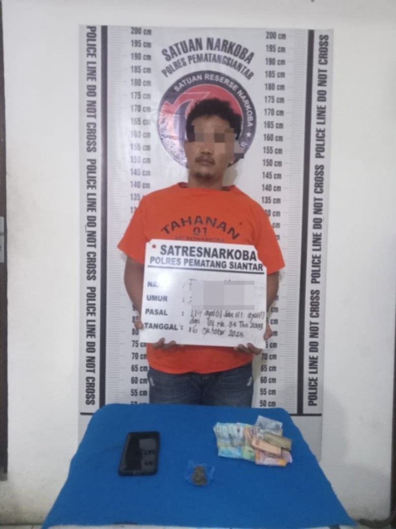 FM, residivis narkoba di Siantar, ditangkap Satresnarkoba Polres Pematangsiantar setelah polisi menemukan ganja disembunyikan di atas pintu rumahnya.