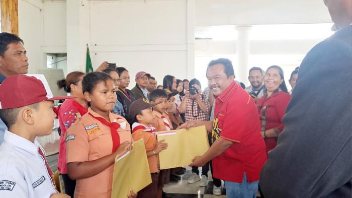 Anggota DPR RI Rapidin Simbolon bersama Bupati Toba Effendi Sintong menyerahkan bantuan Program Indonesia Pintar (PIP) kepada perwakilan siswa di Kabupaten Toba.