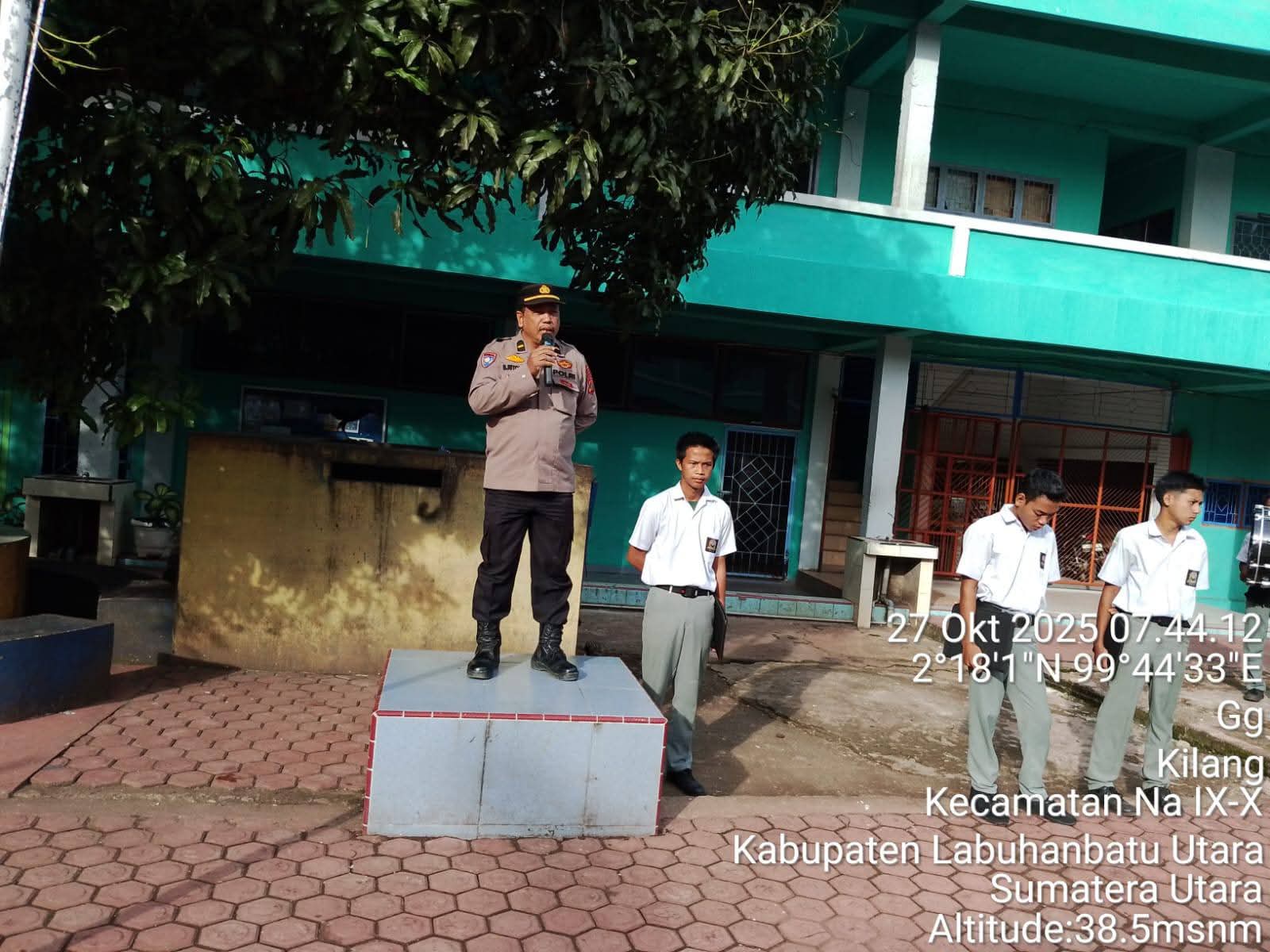 Ipda B. Ritonga dari Polsek Na IX-X menjadi pembina upacara bendera di SMA Negeri 1 Na IX-X dalam kegiatan &ldquo;Police Goes To School&rdquo;, Senin (27/10/2025).