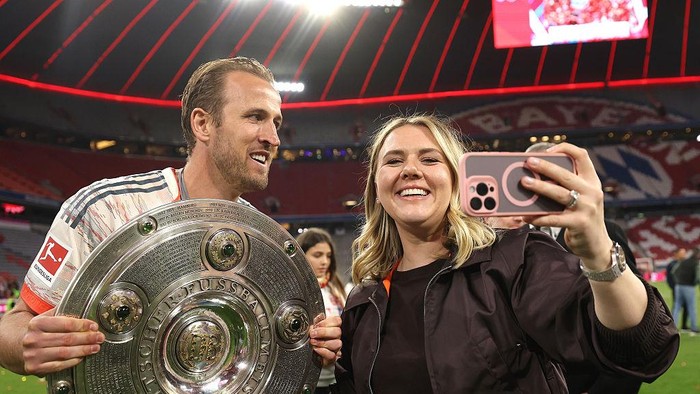 Harry Kane bersama istrinya, Katie Goodwin, dan keempat anak mereka. Katie disebut menjadi alasan utama Kane enggan kembali ke Inggris karena merasa lebih tenang dan bebas dari sorotan media di Jerman