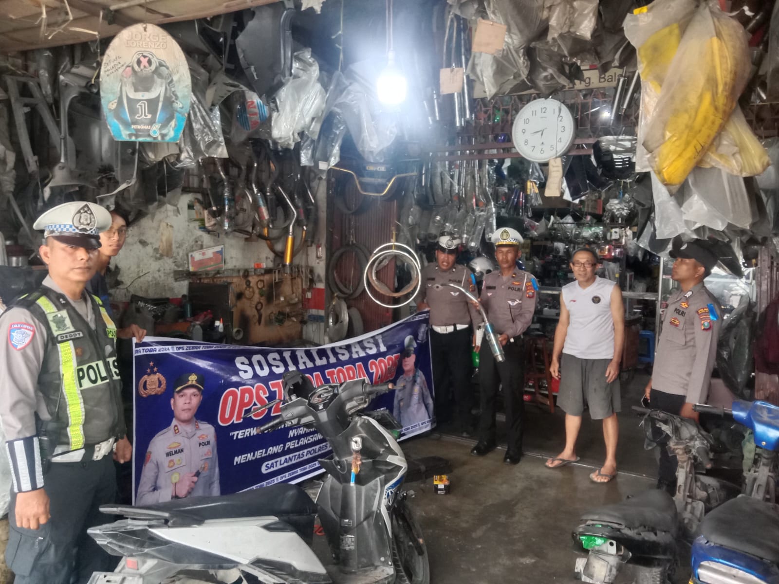 Personel Sat Lantas Polres Tanjungbalai memberikan sosialisasi kepada pemilik Bengkel Camel Motor Racing terkait larangan penjualan dan pemasangan knalpot brong dalam rangka Operasi Zebra Toba 2025.