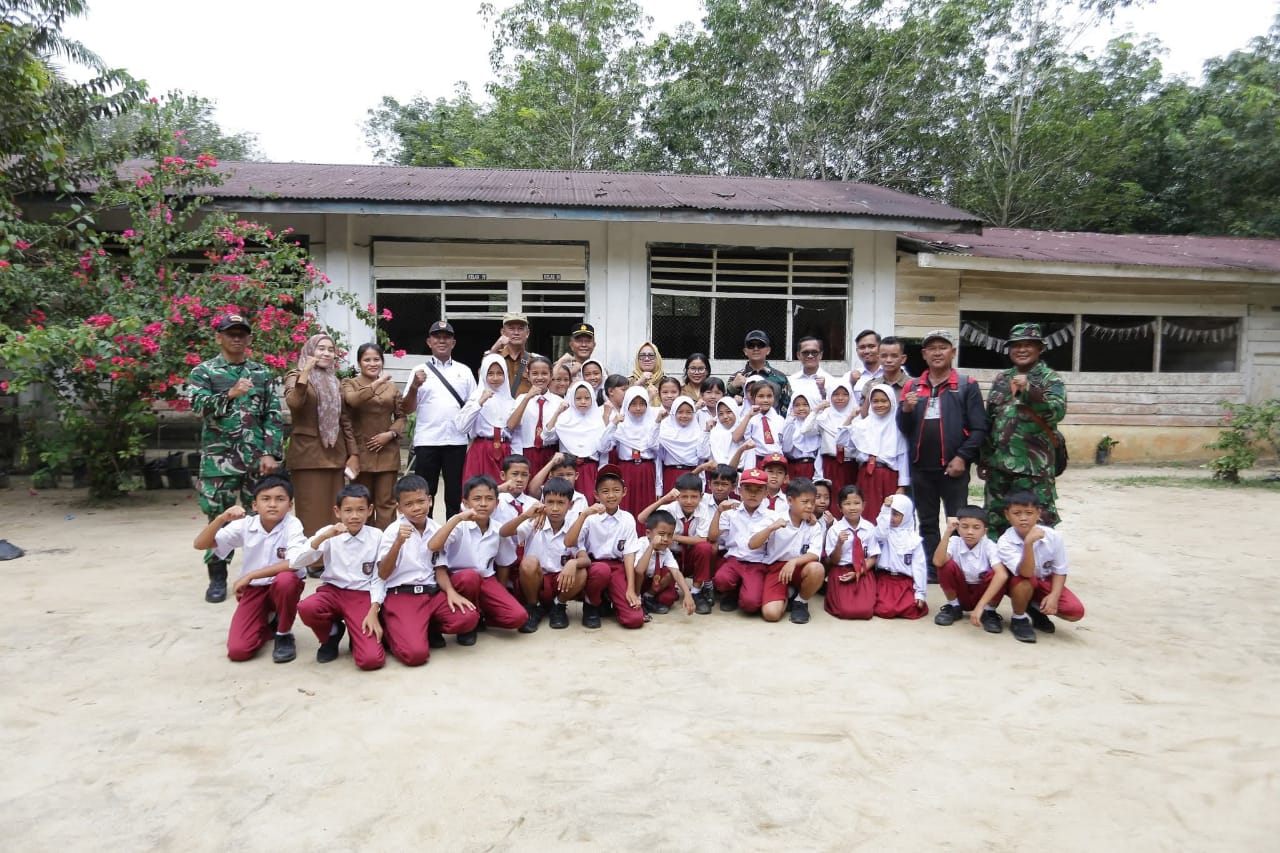 Dandim 0208Asahan Letkol Inf Edy Syahputra foto bersama murid saat meninjau kondisi bangunan SDN 017722 Huta Padang, Kecamatan Bandar Pasir Mandoge, Senin (24/11).