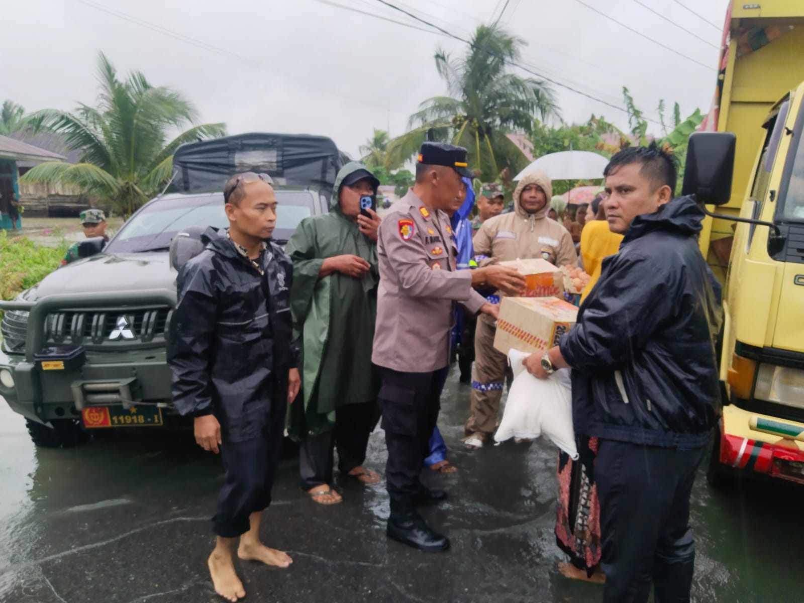 Kapolsek Pantai Cermin AKP FSM Manik bersama aparat TNI dan pemerintah desa menyalurkan bantuan sembako kepada warga terdampak banjir di Desa Pantai Cermin Kiri, Serdang Bedagai, Kamis (27/11/2025).