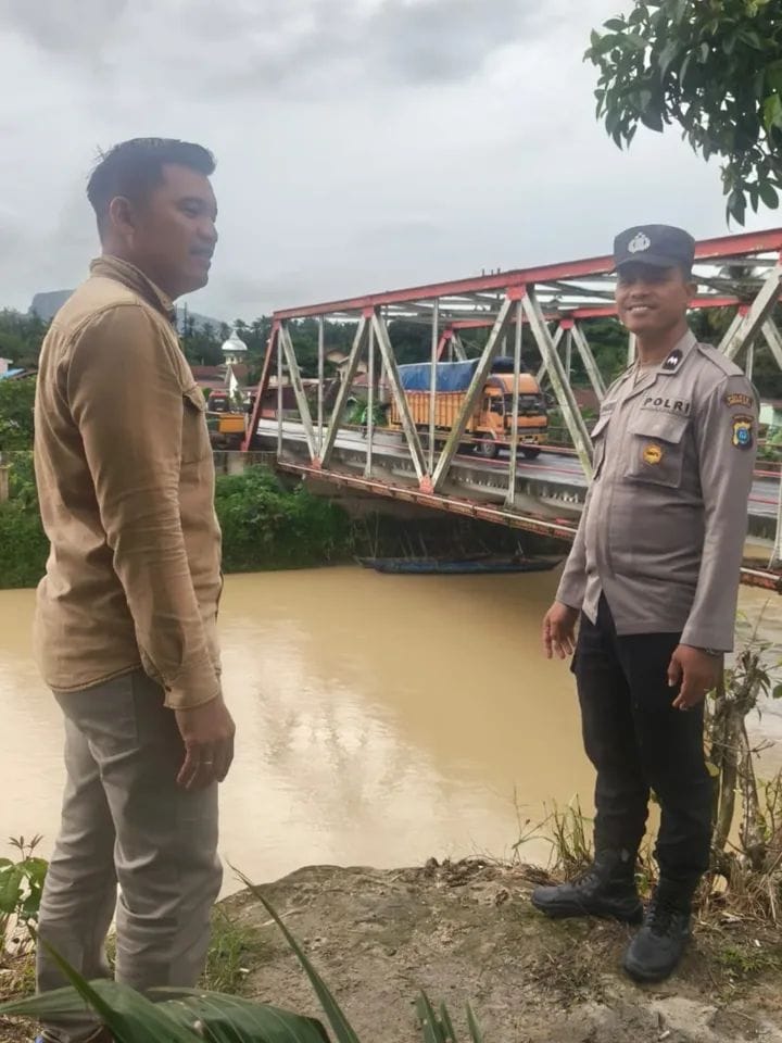 Petugas Polsek Aek Natas saat melakukan pemantauan kondisi sungai di wilayah Labura.