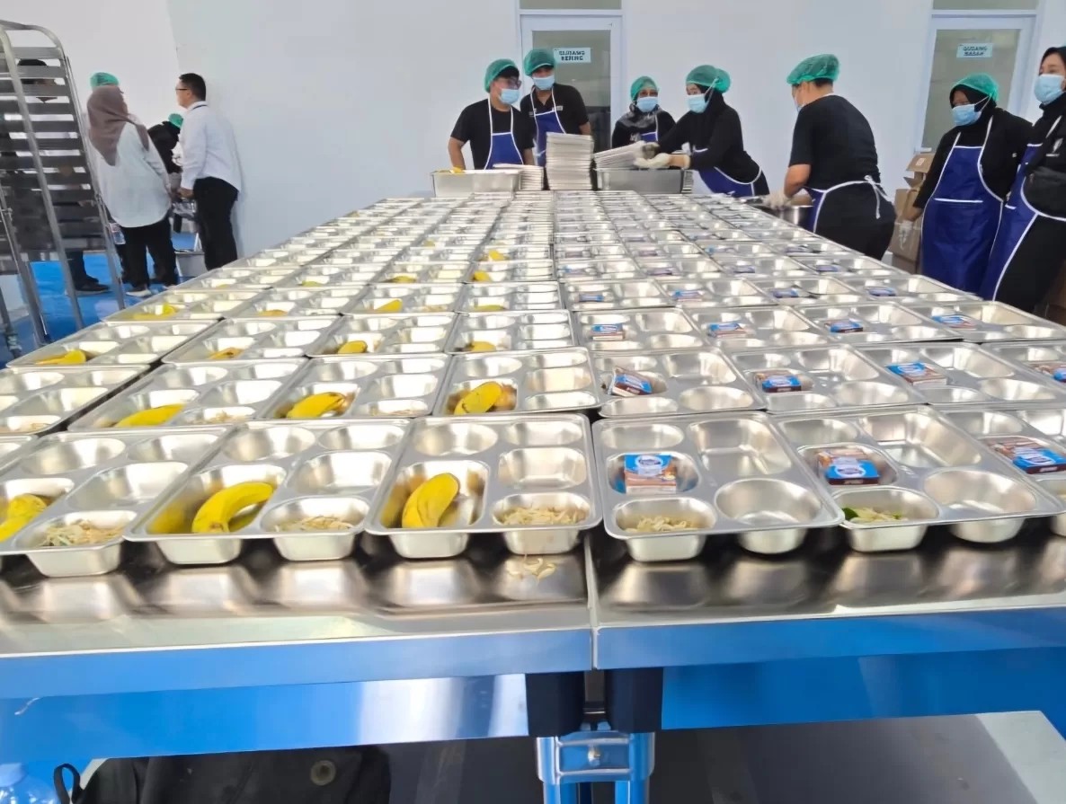 Petugas SPPG menyiapkan paket Makan Bergizi Gratis (MBG) sebelum didistribusikan kepada warga terdampak banjir dan longsor di Sumatera Utara.