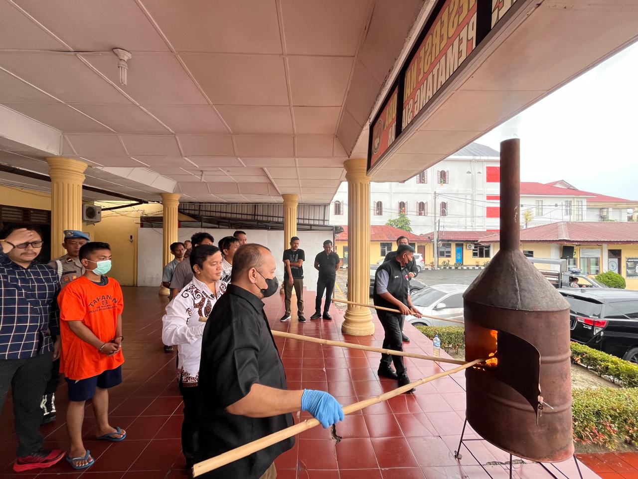 Personel Polres Pematangsiantar memusnahkan barang bukti ganja dengan cara dibakar.