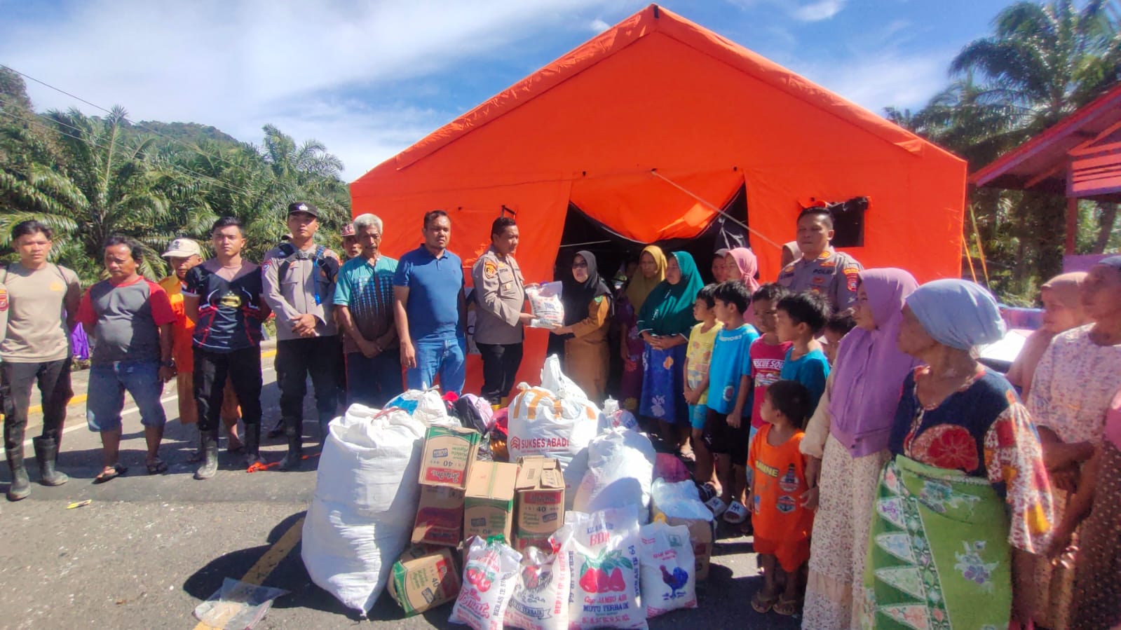 Personel Polres Tapanuli Selatan menurunkan dan menyerahkan bantuan sosial untuk warga terdampak bencana di Kelurahan Reniate, Angkola Sangkunur, Selasa (2/12/2025).