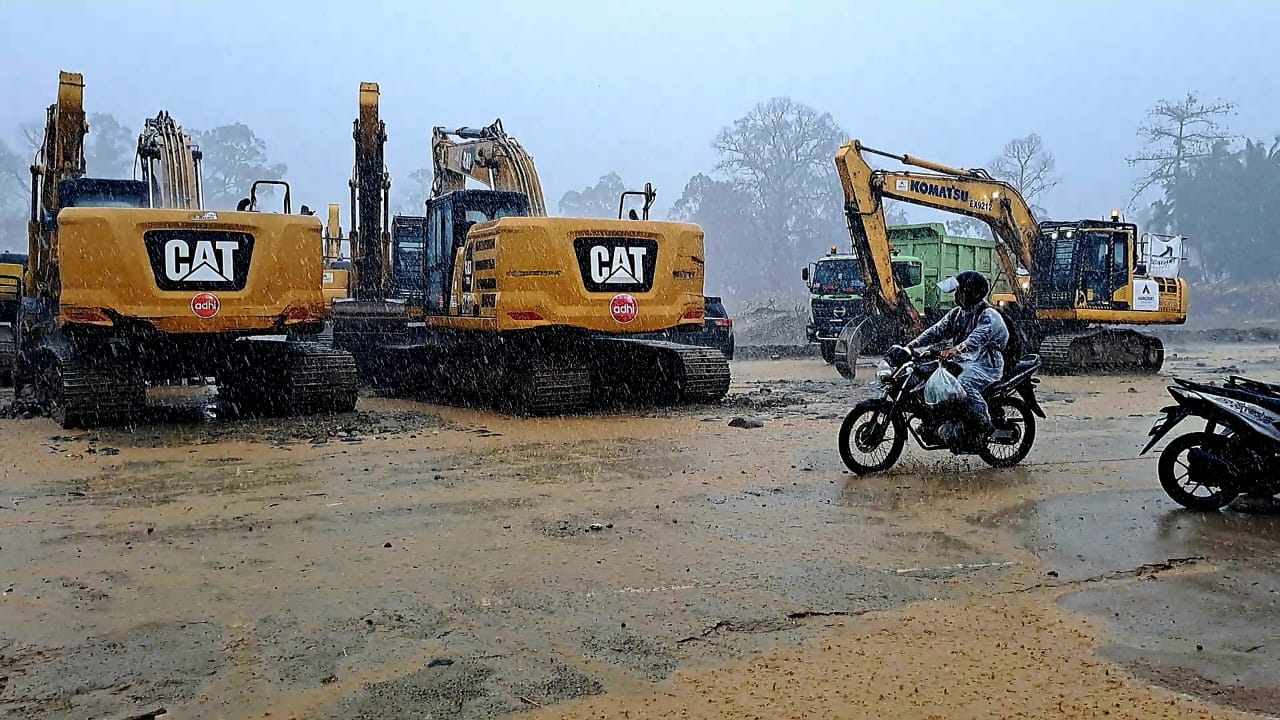 Seorang pengendara dan beberapa ekskavator terlihat menjauh saat Sungai Garoga mulai meluap di Kecamatan Batangtoru, Selasa (9/12/2025) sore.