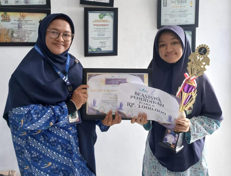 Kepala sekolah SMP IT Darul Hasan, Fatma Muhriza Nasution serahkan piala, piagam dan uang pembinaan kepada Khadizah Romaito Nauli Harahap.