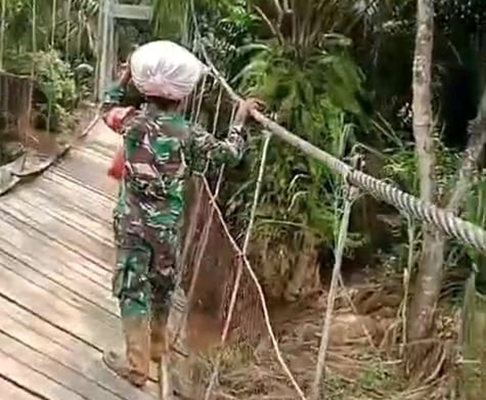 Kapten Inf H. Sirait dan anggota Koramil 19 Siais berjalan kaki 4 km memikul bantuan untuk korban banjir bandang di Lombang Dolok, Angkola Selatan.