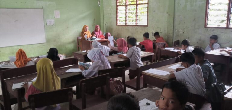 Siswa SD mengikuti ujian di lokasi darurat setelah sekolah mereka rusak dan dipenuhi lumpur akibat banjir.