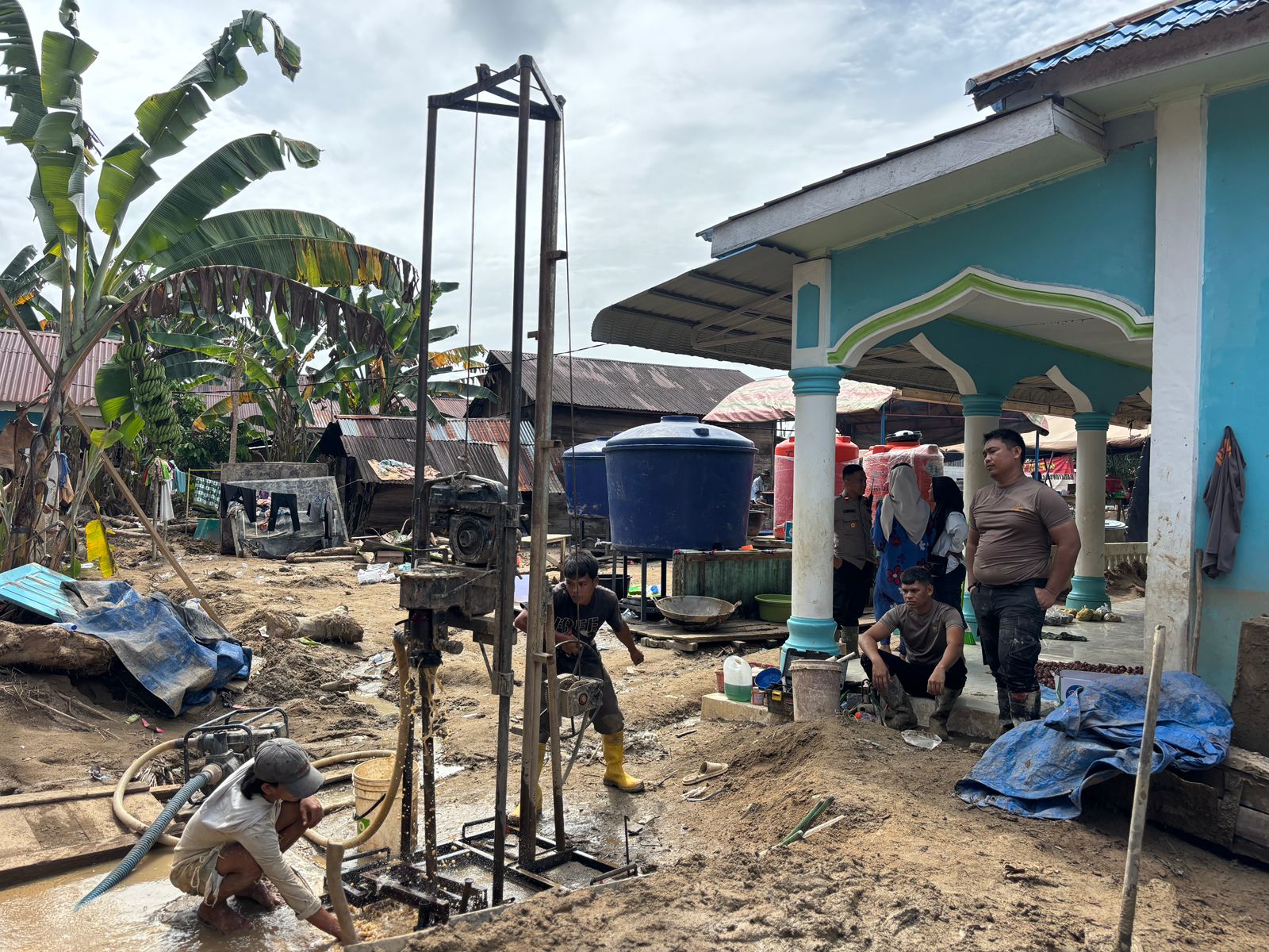 Personel Brimob Polda Sumut membersihkan masjid, rumah warga, dan membantu pembuatan sumur bor di Desa Aek Ngadol, Batang Toru, pascabanjir.