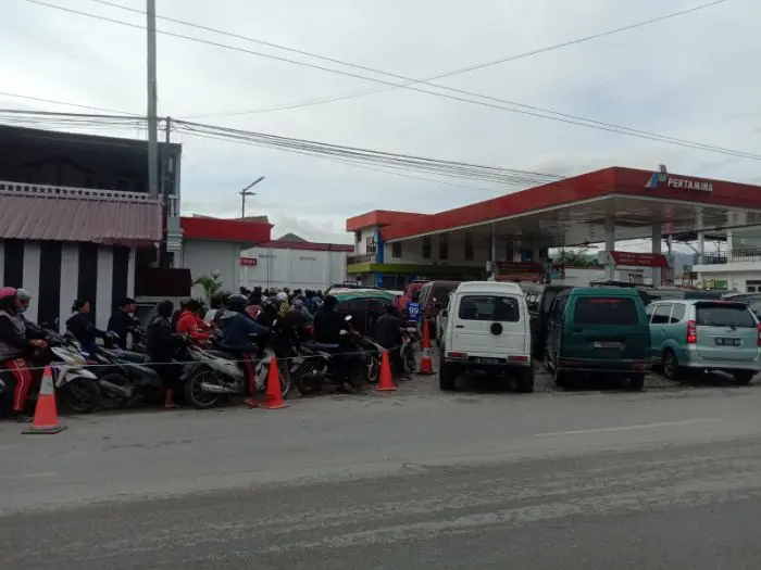 Pengendara antre di SPBU Porsea, Toba, meski stok BBM aman, akibat distribusi tidak merata dan penjualan eceran dengan harga tinggi.