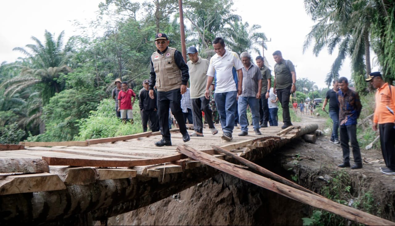 Bupati Simalungun Anton Achmad Saragih meninjau sekaligus melintasi jembatan darurat di ruas jalan Dolok Silau&ndash;Silou Kahean yang putus akibat longsor.