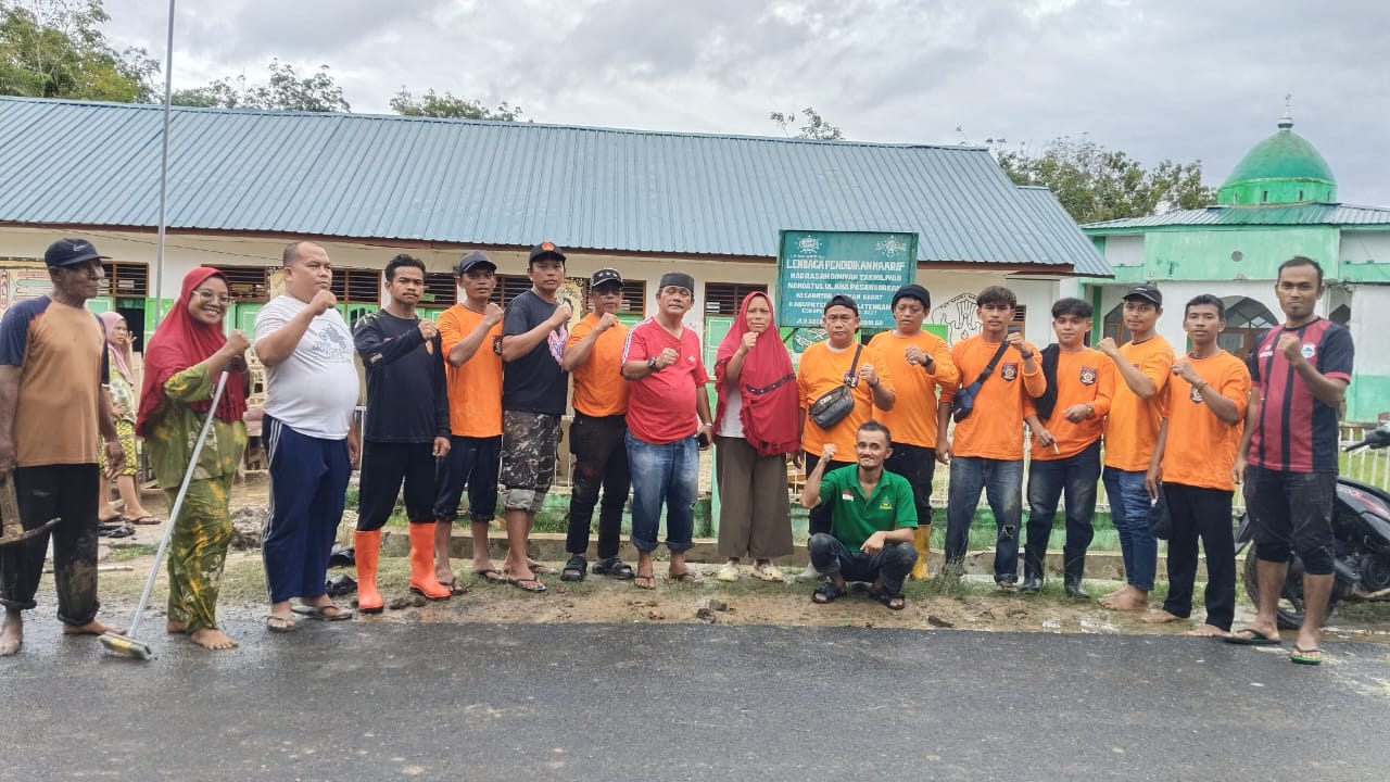 Personel Bagana Banser NU Tapteng membersihkan sisa lumpur di lingkungan MIS NU Pasar Sorkam pasca banjir bandang, Minggu (14/12/2025).