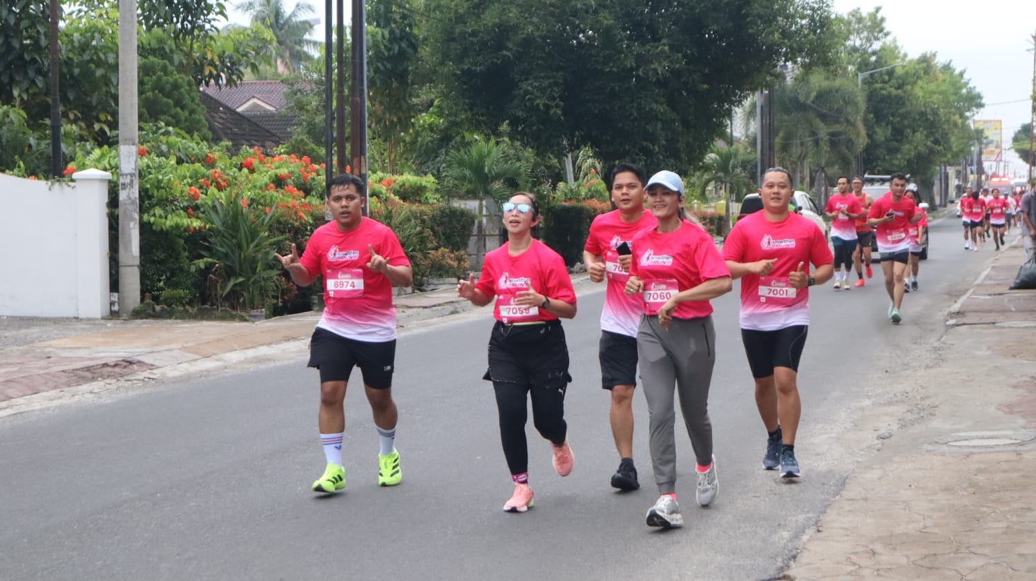 Kapolres Pematangsiantar AKBP Sah Udur Togi Marito Sitinjak berbaur bersama peserta saat mengikuti Fun Run Smartfren di Lapangan Adam Malik, Minggu (14/12/2025).