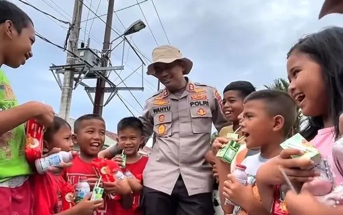 Kapolres Tapanuli Tengah AKBP Wahyu Endrajaya berinteraksi dan membagikan susu kepada anak-anak korban banjir saat patroli pengecekan sumur bor di Pandan.