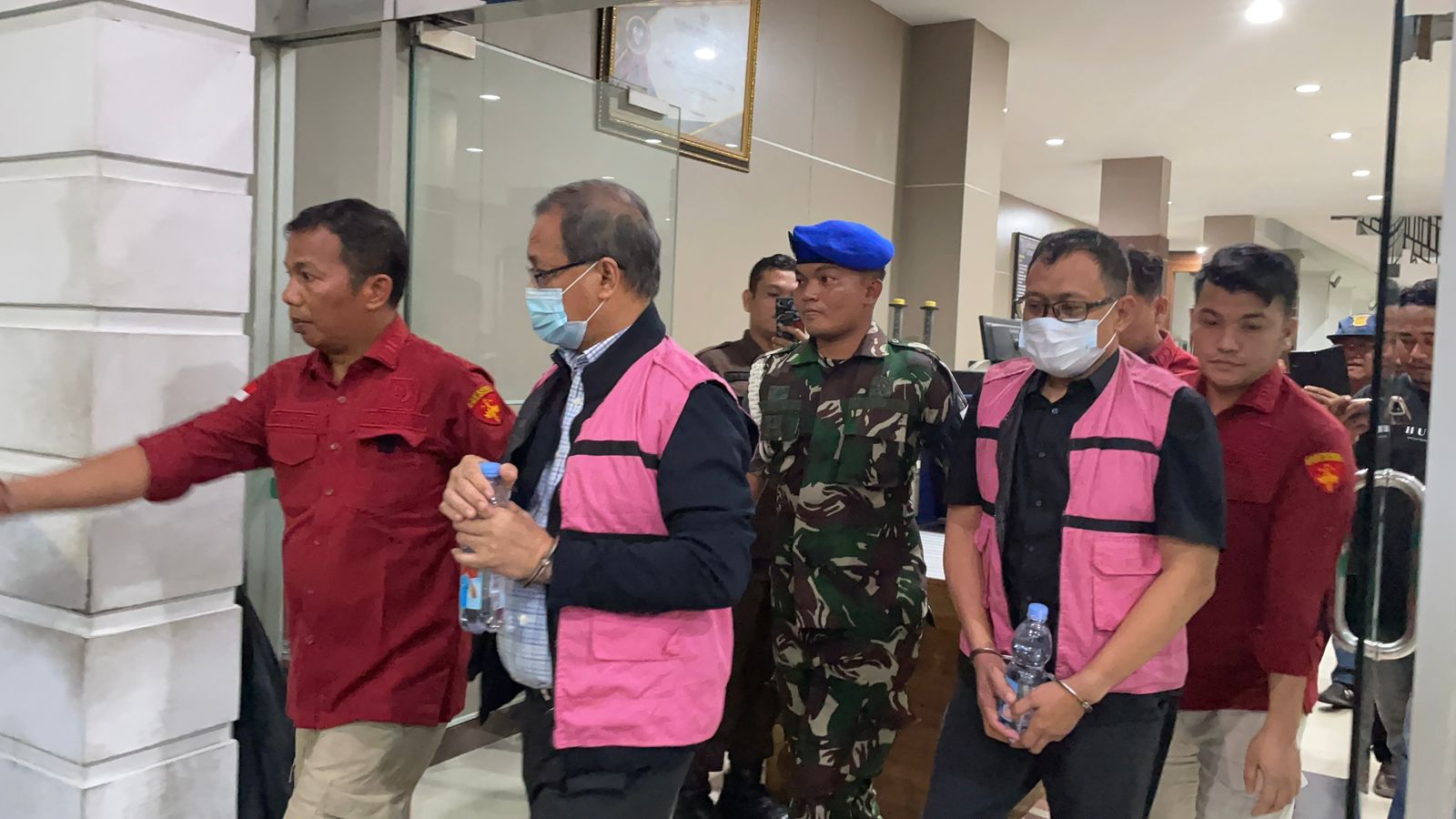 Petugas Kejaksaan Tinggi Sumatera Utara menggiring dua tersangka kasus dugaan korupsi penjualan aluminium alloy PT Inalum usai pemeriksaan di Medan, Rabu (17/12/2025).