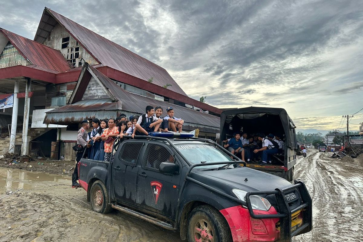 Personel Polda Sumatera Utara mengantar anak-anak sekolah dari lokasi pengungsian Desa Huta Godang, Batang Toru, Tapsel, menggunakan mobil dinas pascabanjir dan longsor.