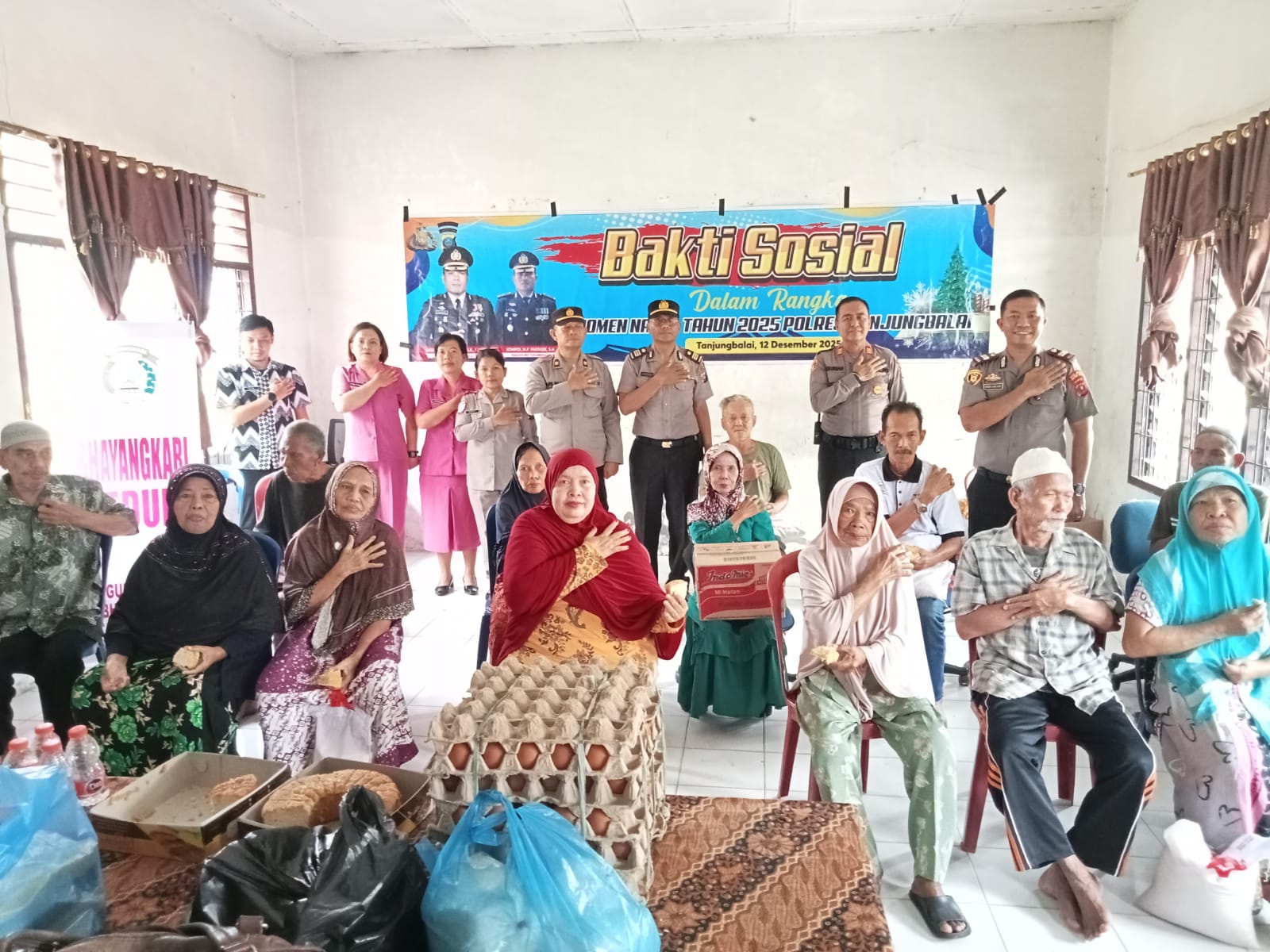 Jajaran Polres Tanjungbalai menyerahkan paket Natal saat kunjungan bakti sosial ke panti jompo menjelang perayaan Natal 2025.