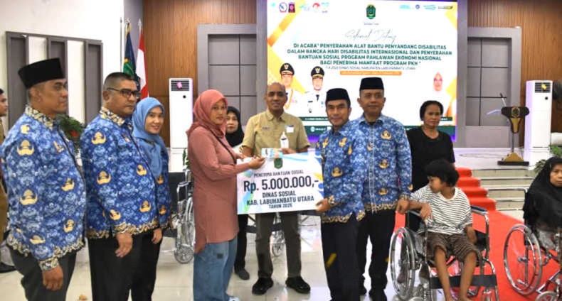 Wakil Bupati Labura, Dr. H. Samsul Tanjung, menyerahkan alat bantu kepada penyandang disabilitas pada peringatan Hari Disabilitas Internasional 2025.