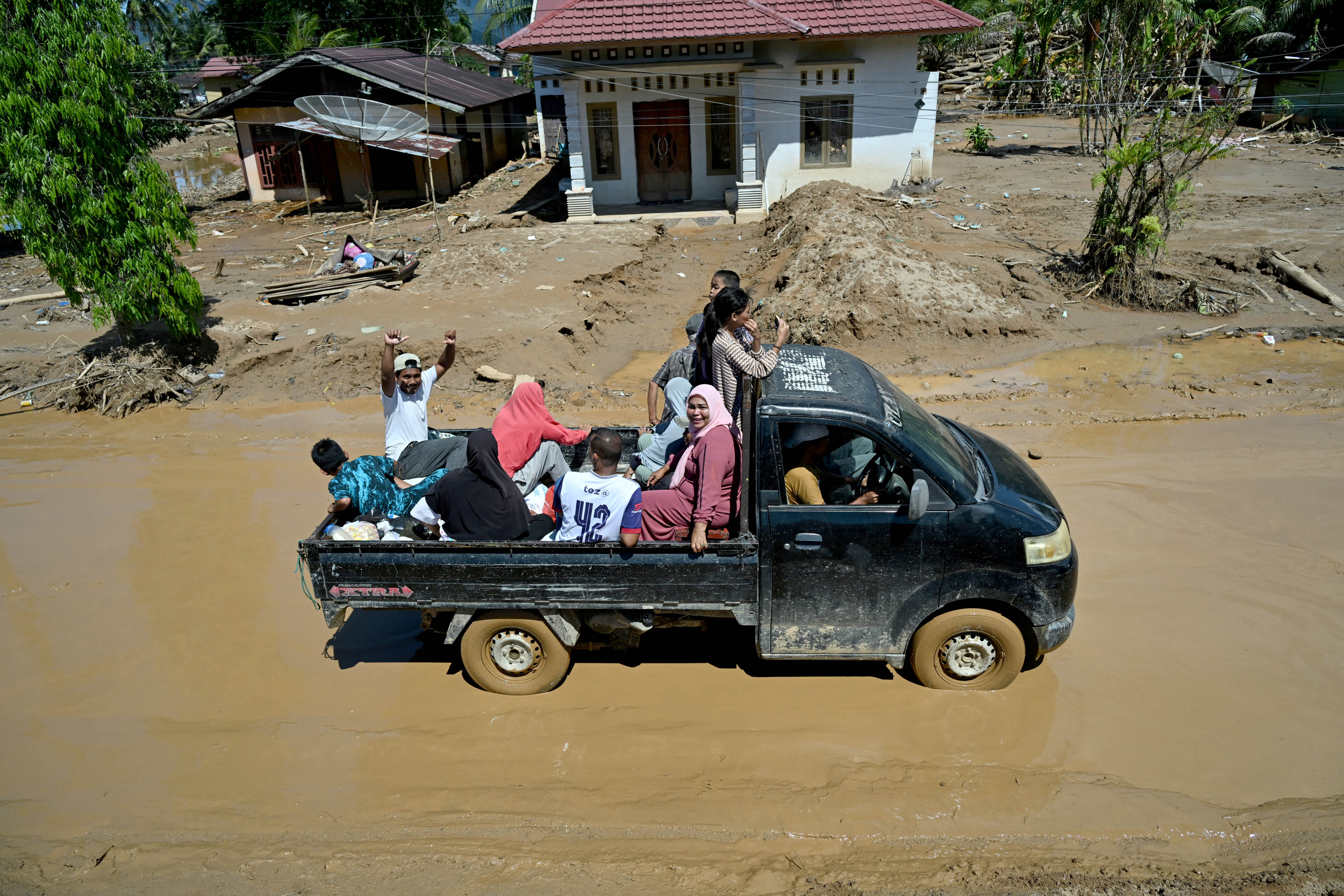 Warga melintasi genangan banjir yang masih tersisa di Desa Tukka, Kecamatan Tukka, Kabupaten Tapanuli Tengah, menggunakan kendaraan roda dua dan roda empat.