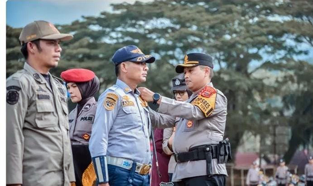 Kapolres Padangsidimpuan AKBP Dr. Wira Prayatna menyematkan pita tanda dimulainya Operasi Lilin Toba 2025 dalam apel gelar pasukan.