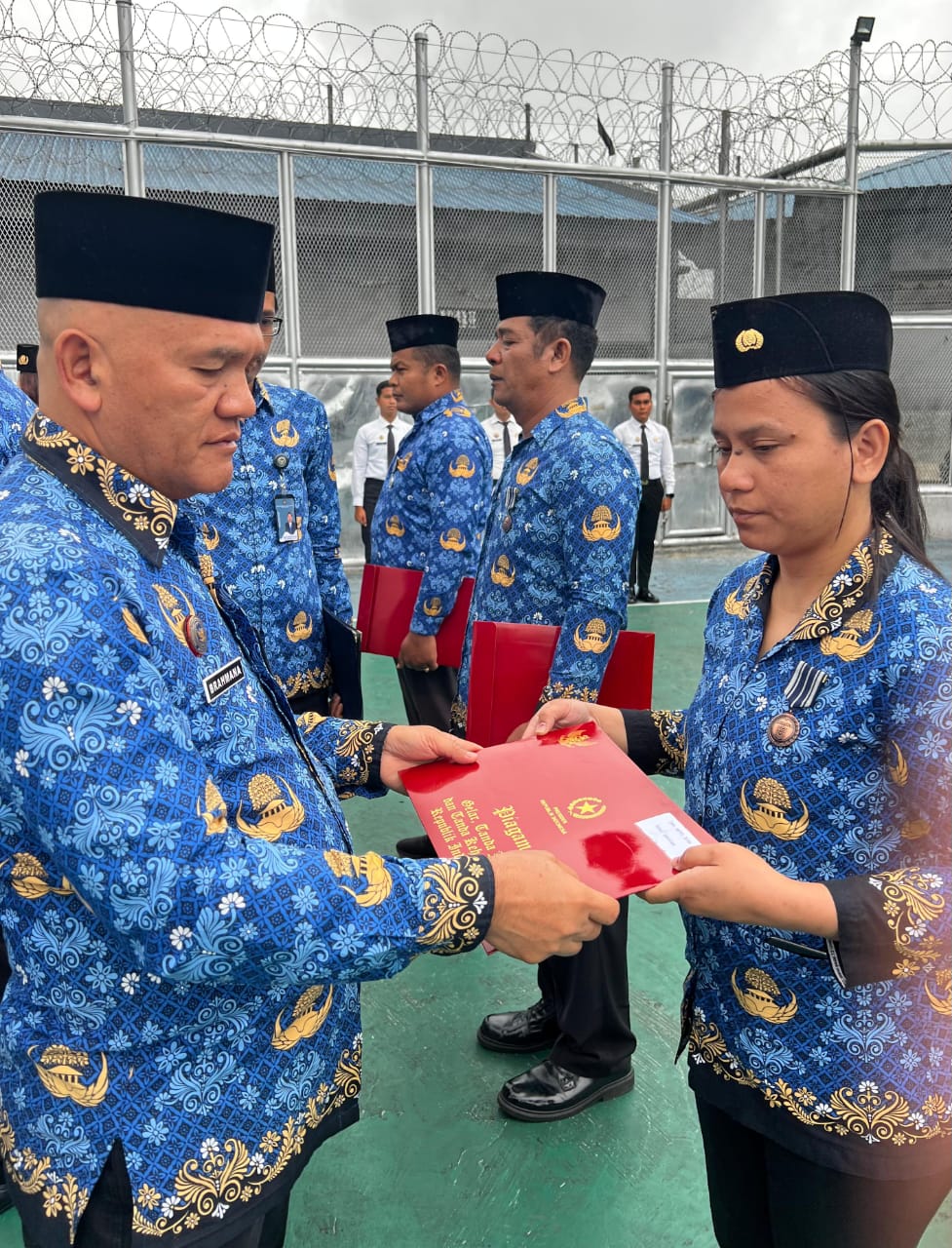 Kepala Rutan Kabanjahe Bahtiar Sembiring menyematkan Satyalencana Karya Satya kepada pegawai saat Upacara Hari Kesadaran Nasional di Rutan Kabanjahe.