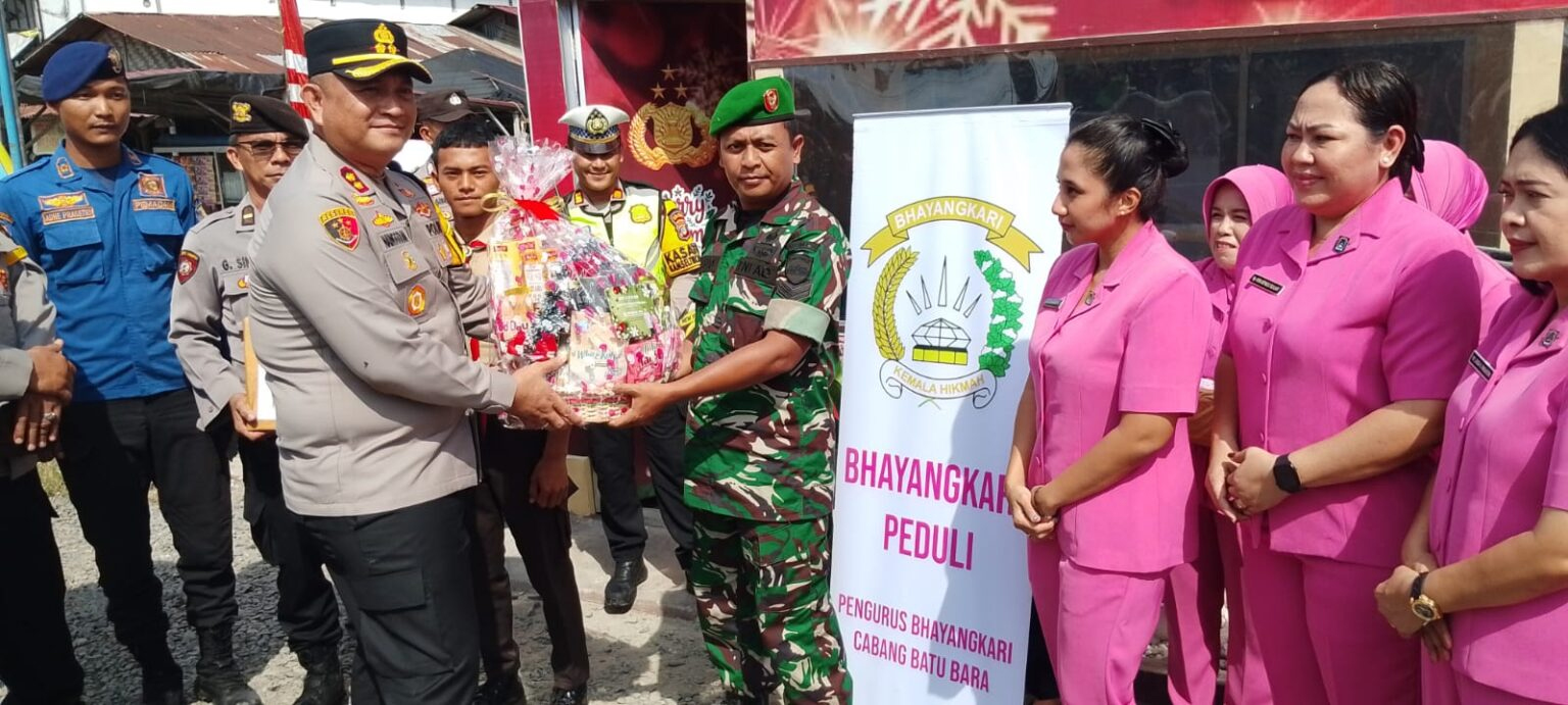 Kapolres Batubara AKBP Doly Nelson Nainggolan menyerahkan bingkisan Natal kepada personel di Pos Pelayanan Nataru Pintu Tol Lima Puluh.