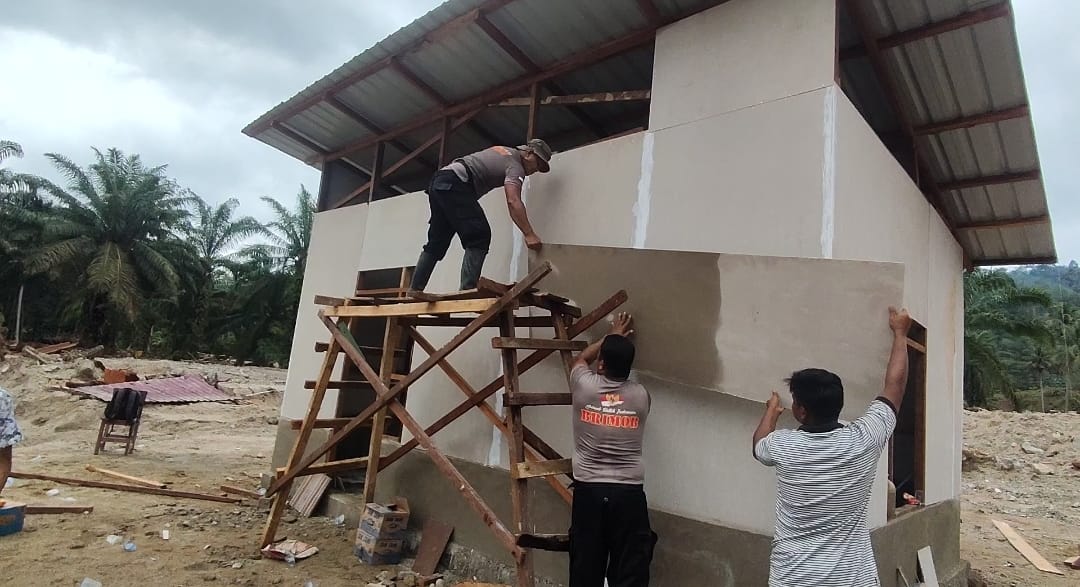 Personel Brimob Polda Sumut bersama TNI dan warga bergotong royong membangun hunian sementara bagi korban banjir di Desa Tolang Julu, Tapanuli Selatan.