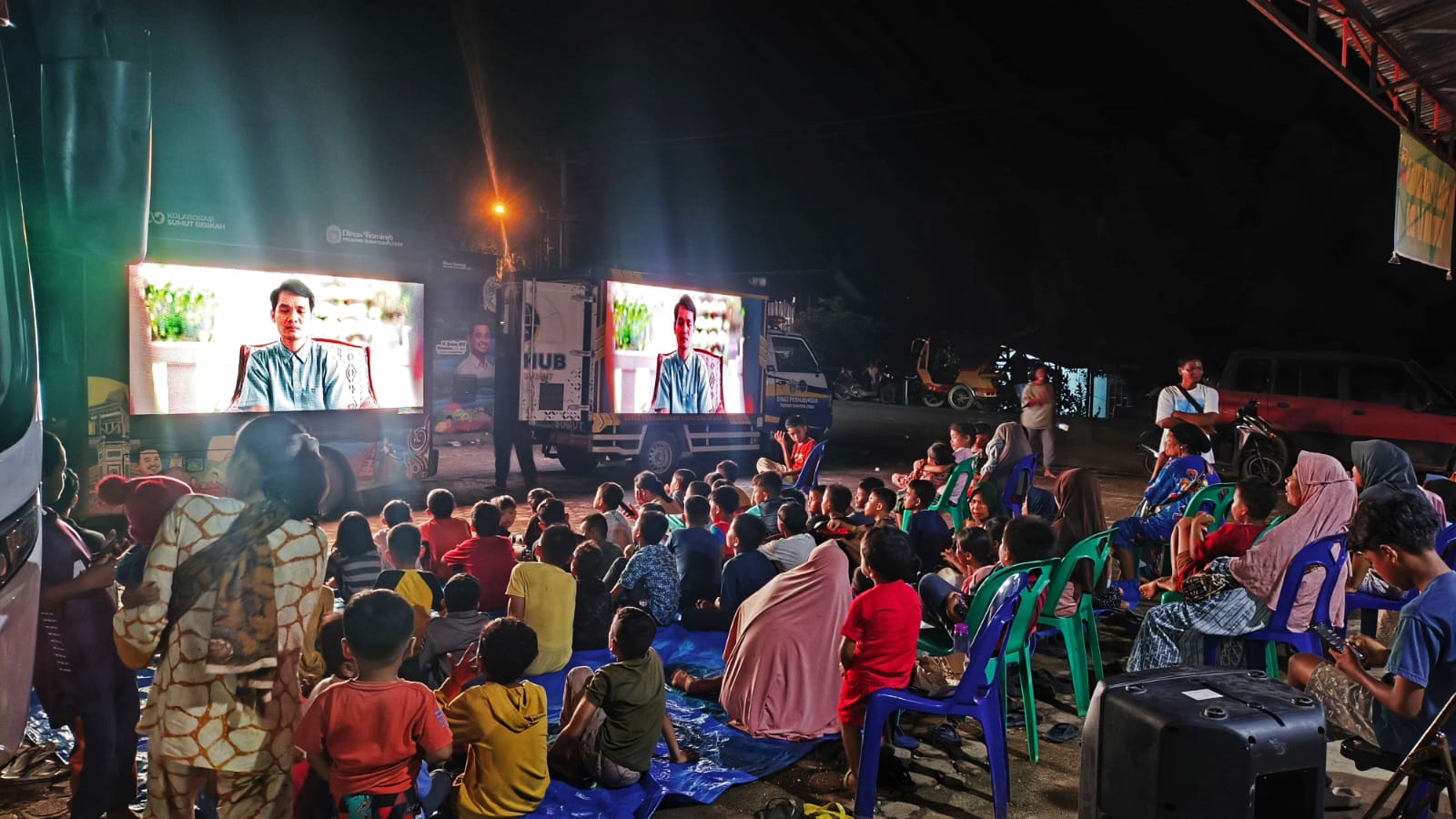 Relawan dan warga terdampak banjir serta longsor dari Desa Garoga, Hutagodang, dan Ngandol menonton film Agak Laen melalui mobil videotron Pemprov Sumut di Posko Pengungsian Batuhula, Tapanuli Selatan