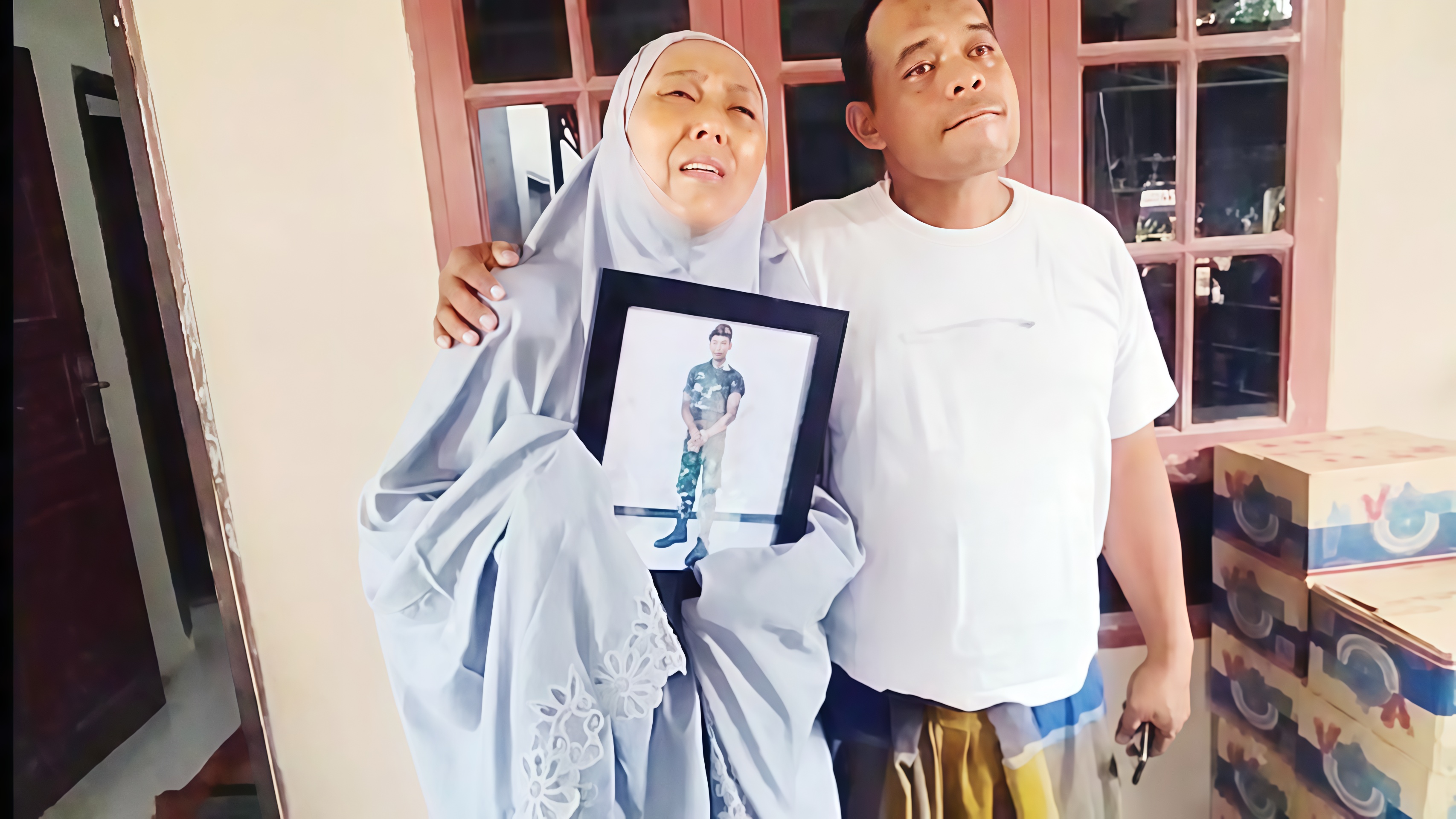 Marsinah Wati Silalahi menunjukkan foto putranya, Pratu Farkhan Sauqi Marpaung, saat prosesi pemakaman militer di Kabupaten Asahan.
