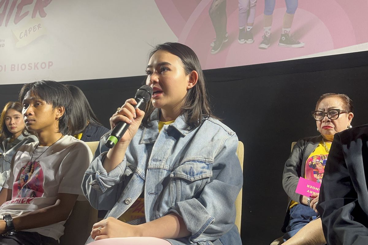 Amanda Manopo tampil mengenakan mahkota dan selempang putri kecantikan dalam poster resmi film Check Out Sekarang, Pay Later (CAPER).