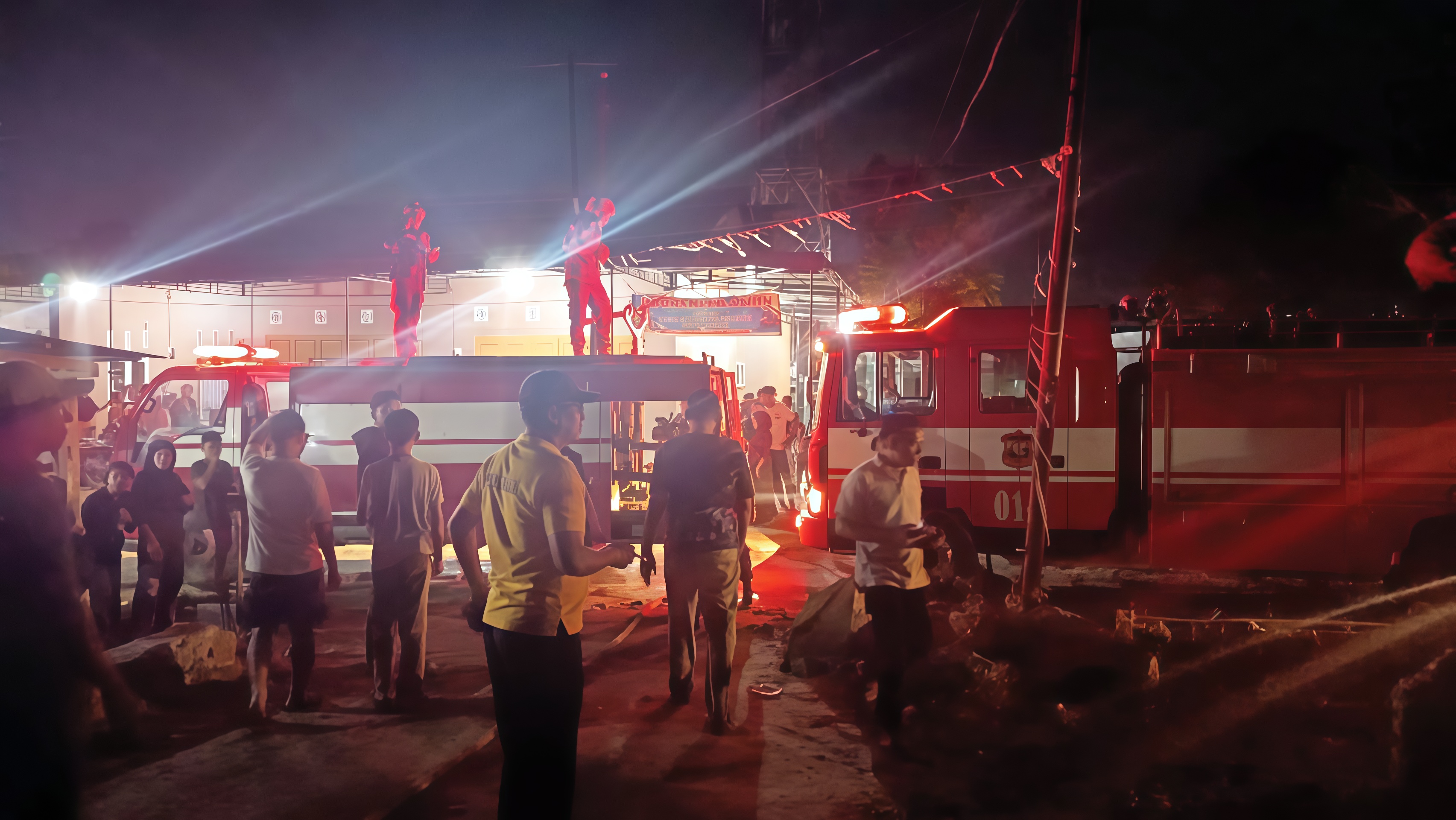 Petugas pemadam kebakaran saat memadamkan api yang melahap satu rumah warga di Pulau Simardan, Tanjungbalai.